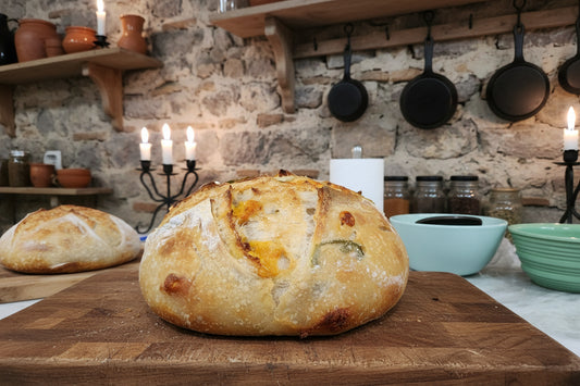 Loaf of cheddar jalapeno sourdough bread sitting on a cutting board